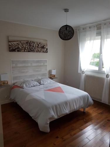 une chambre avec un grand lit blanc et deux fenêtres dans l'établissement Maison Napoléon, à Wimille