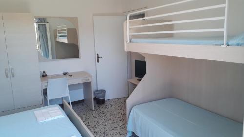 ポルト・アッズッロにあるAlbergo Bel Tramontoの二段ベッド1組、デスクが備わる小さな客室です。
