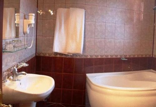 La salle de bains est pourvue d'un lavabo, de toilettes et d'une baignoire. dans l'établissement Hotel Maria, à Râmnicu Vâlcea