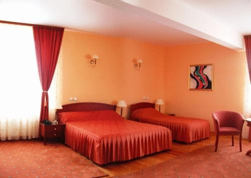ein Hotelzimmer mit 2 Betten und einem Stuhl in der Unterkunft Hotel Maria in Râmnicu Vâlcea