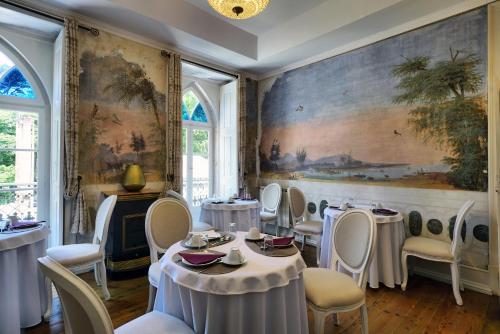 een eetkamer met tafels en stoelen en een schilderij aan de muur bij Charm Inn Sintra in Sintra