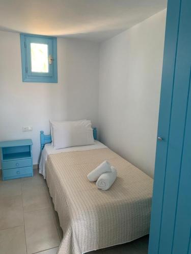 a bedroom with a bed with two pillows on it at Fortina Mykonos house in Klouvas