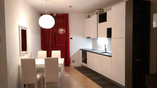 a kitchen with a table and chairs and a red curtain at Darsena 7 in Peschiera del Garda