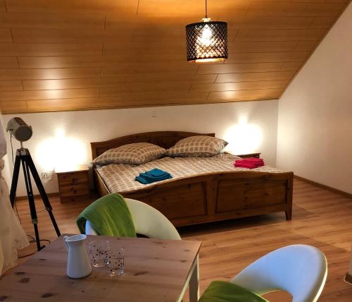 um quarto com uma cama, uma mesa e cadeiras em Steinbachblick em Steinbach am Wald