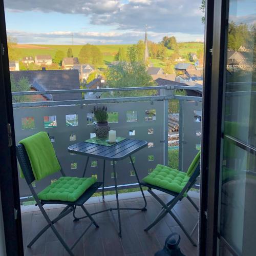 a balcony with a table and chairs and a view at Steinbachblick in Steinbach am Wald