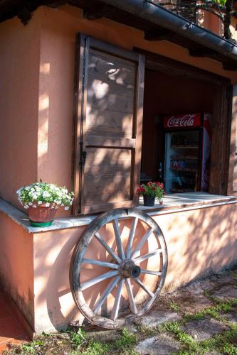 an old woodenoked wheel in front of a cocacola store at Antico Borghetto - Casa Vacanze in Norcia