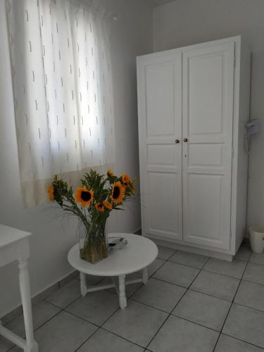 a vase of sunflowers sitting on a table in a room at Fortina Mykonos house in Klouvas