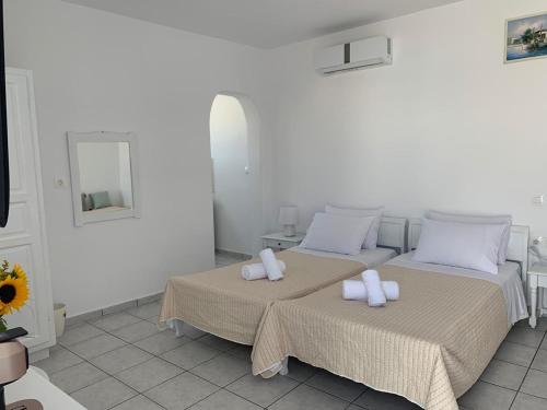 two beds in a white room with towels on them at Fortina Mykonos house in Klouvas