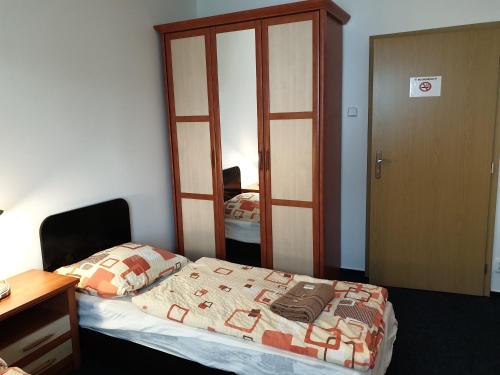a small bedroom with a bed and a mirror at Apartmany Chodov in Prague