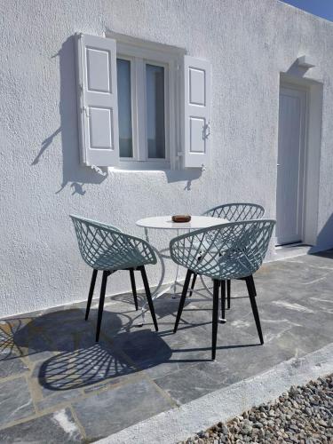 a table and two chairs in front of a building at Fortina Mykonos house in Klouvas
