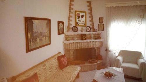 a living room with a fireplace and a chair at Big apartment near Olympus mountain in Litochoro