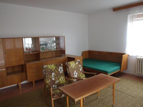 a room with a table and chairs and a bench at Apartmán in Dolní Bukovsko