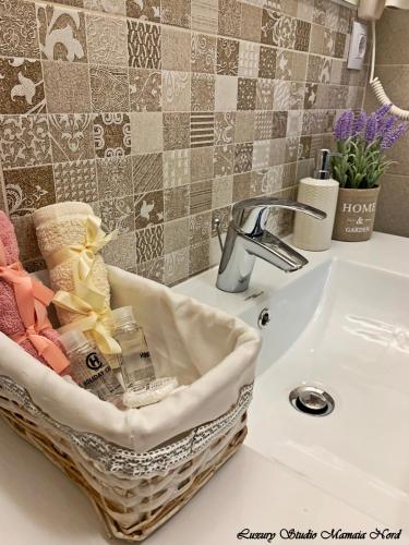 a basket of towels sitting on a bathroom sink at Luxury Studio Mamaia Nord in Mamaia Sat/Năvodari