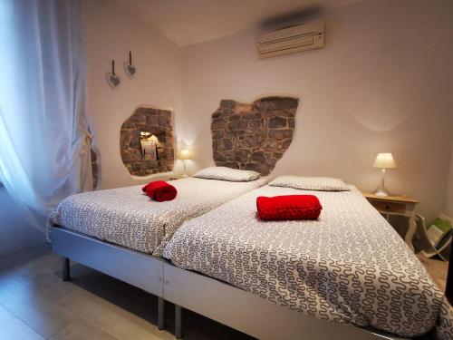 ROMANTIC APARTMENT Lovran - 4 stars في لوفران: غرفة نوم بها سرير ووسادتين حمرا