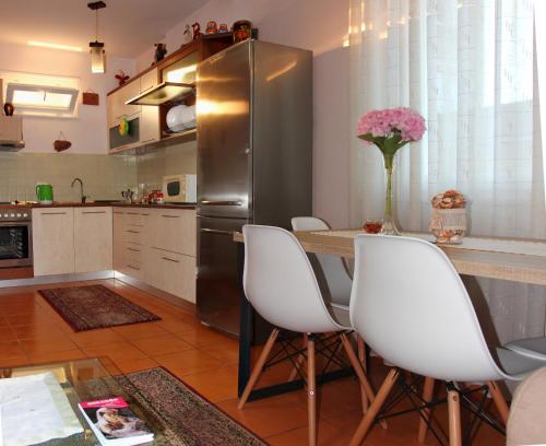 a kitchen with a table and a stainless steel refrigerator at All Seasons Apartments - Free Parking & City Center in Shkodër