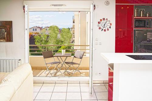 Il comprend une cuisine avec un balcon doté d'une table et de chaises. dans l'établissement Appart'cosy Lyon Est, à Décines-Charpieu