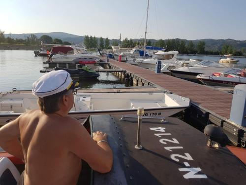 a man sitting on a boat at a dock at Sobe EMILIJA in Veliko Gradište