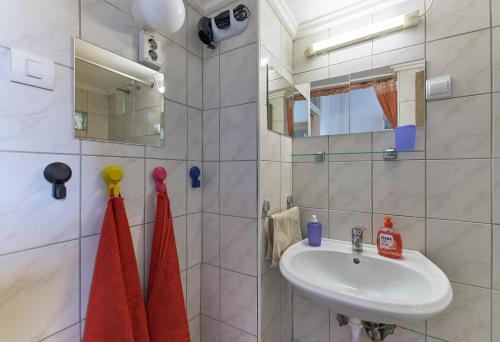 uma casa de banho branca com um lavatório e um espelho em LEM Suburban Apartment em Budapeste