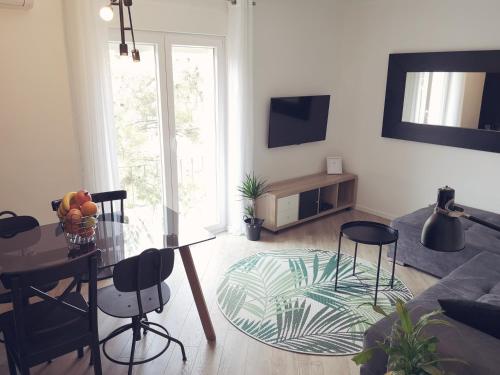 a living room with a glass table and chairs at Apartment Gervais Rijeka in Rijeka