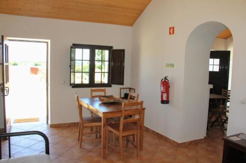 a living room with a table and a fire extinguisher on the wall at Monte Costa LuZ in Porto Covo