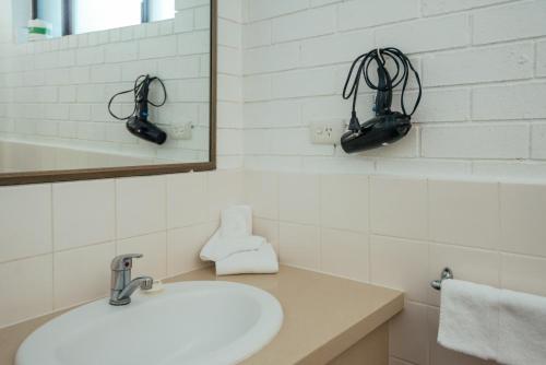 a bathroom with a sink and a mirror at Coffs Windmill Motel in Coffs Harbour