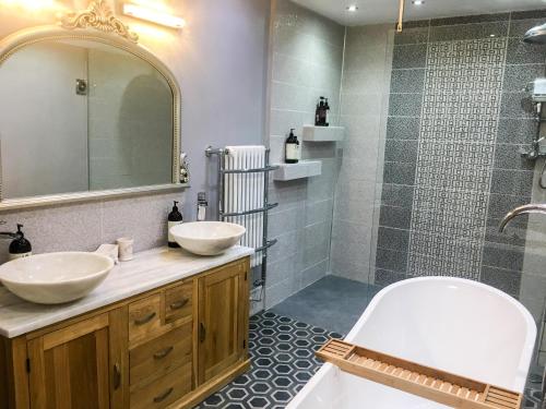 un baño con dos lavabos y una ducha en East Bank Apartment, en Grange-over-Sands