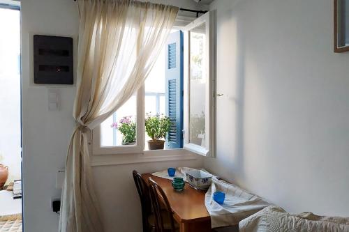 stół jadalny oraz okno ze stołem i krzesłami w obiekcie Aithra -cosy studio in centre of Poros w Poros
