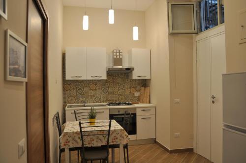 eine kleine Küche mit einem Tisch und einem Herd in der Unterkunft Alexis Home in Neapel