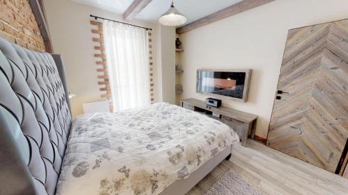 a bedroom with a bed and a tv on a wall at Apartmán Sofia s infrasaunou, PRIMO, Starý Smokovec in Smokovce