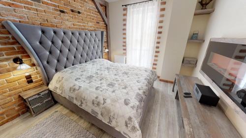 a bedroom with a bed and a brick wall at Apartmán Sofia s infrasaunou, PRIMO, Starý Smokovec in Vysoke Tatry - Novy Smokovec