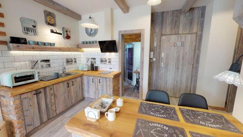 a kitchen with wooden cabinets and a table and chairs at Apartmán Sofia s infrasaunou, PRIMO, Starý Smokovec in Smokovce