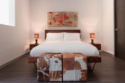a bedroom with a large bed with a wooden headboard at BEE Suites Santa Ana in Santa Ana