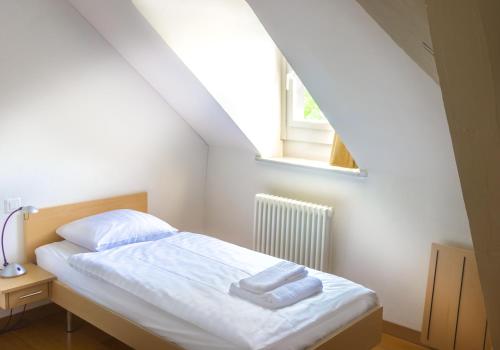 a bedroom with a bed with white sheets and a window at Château de Bossey in Bogis-Bossey