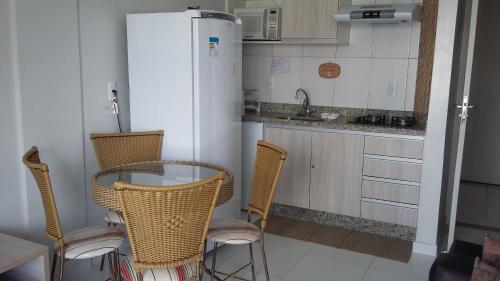 cocina con mesa, sillas y nevera en Apartamento no Lagoa Quente Flat Service, en Caldas Novas