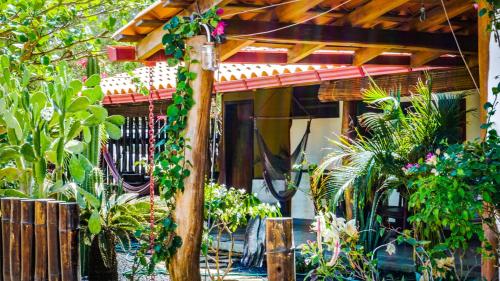 a house with a bunch of plants in front of it at Vibra Guesthouse Popoyo in Popoyo