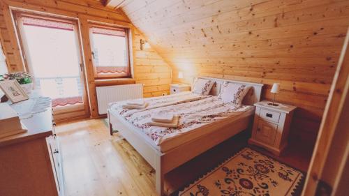 Jaśkowa Chata في ستريشافا: غرفة نوم بسرير في كابينة خشبية