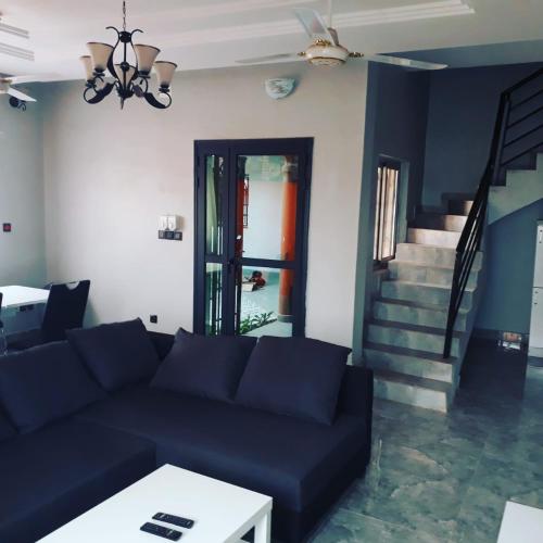 a living room with a blue couch and stairs at RESIDENCE L'ESCALE équipements moderne in Bamako