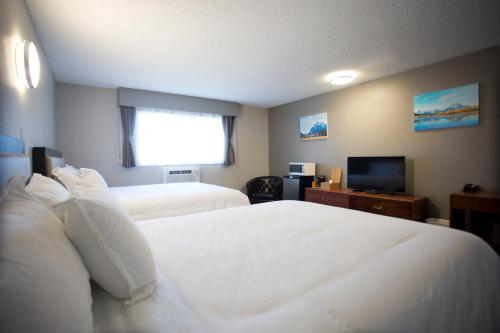 a hotel room with two beds and a television at Valemount Vacation Inn in Valemount