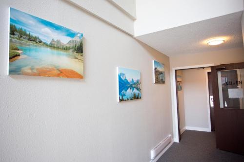 a hallway with three paintings on the wall at Valemount Vacation Inn in Valemount