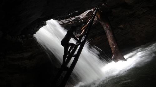 a person standing on a ladder in front of a waterfall at Hotel Palmar del Río Premium in Archidona