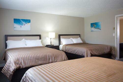 two beds in a hotel room with two beds at Valemount Vacation Inn in Valemount