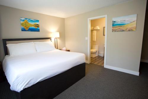 a hotel room with a large bed and a bathroom at Valemount Vacation Inn in Valemount