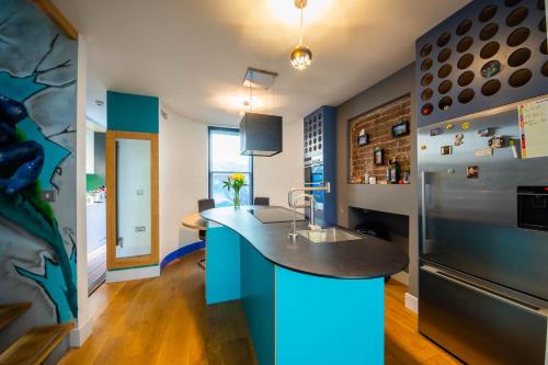a kitchen with a blue island in the middle at Funky Home by the Pier, 3 Bedrooms, Sleeps 10 in Brighton & Hove