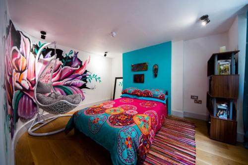 a bedroom with a colorful bed and a painting on the wall at Funky Home by the Pier, 3 Bedrooms, Sleeps 10 in Brighton & Hove