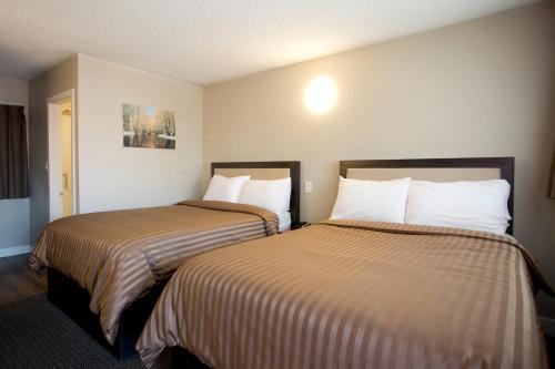 two beds in a hotel room with two beds at Valemount Vacation Inn in Valemount