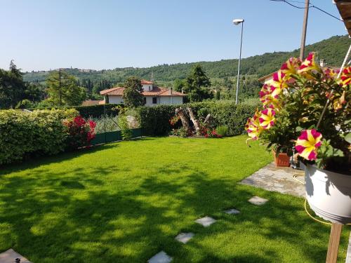 a yard with green grass and flowers and a house at Vicus House in Viciomaggio