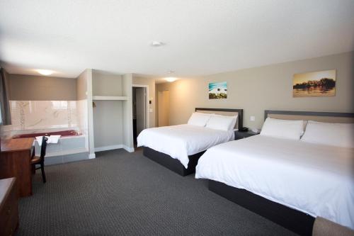 a hotel room with two beds and a desk at Valemount Vacation Inn in Valemount