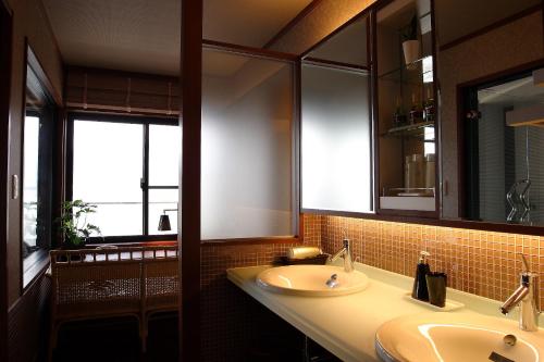 a bathroom with two sinks and a mirror at Fujikawaguchiko Onsen Konanso in Fujikawaguchiko