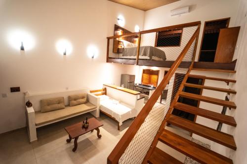 a living room with a staircase and a couch at Vila Loop in São Miguel do Gostoso