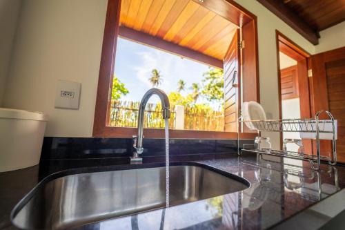 a kitchen with a sink and a window at Vila Loop in São Miguel do Gostoso